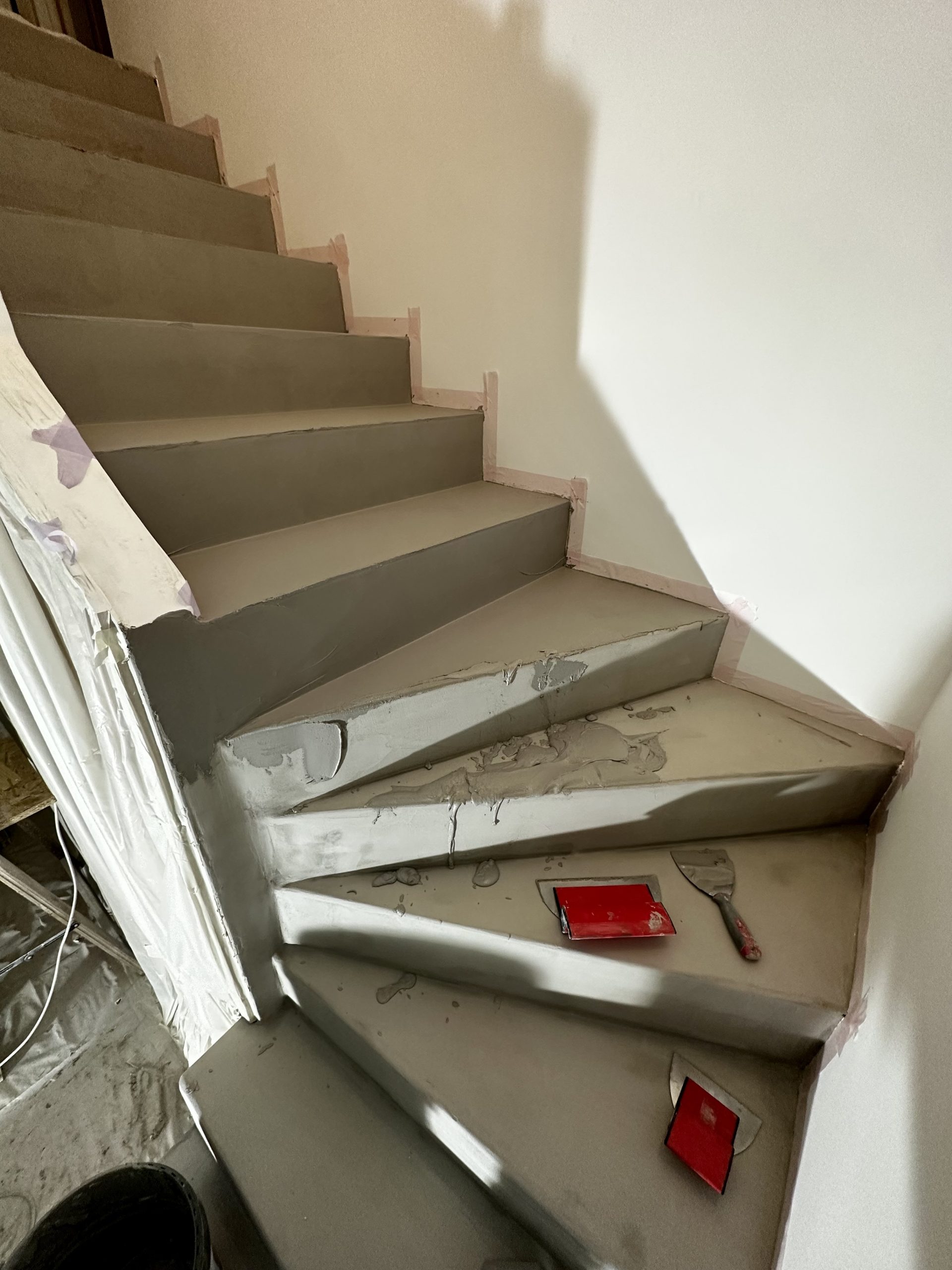 Escalier intérieur en béton ciré gris finition moderne à Carqueiranne par Clavel Rénovation.

