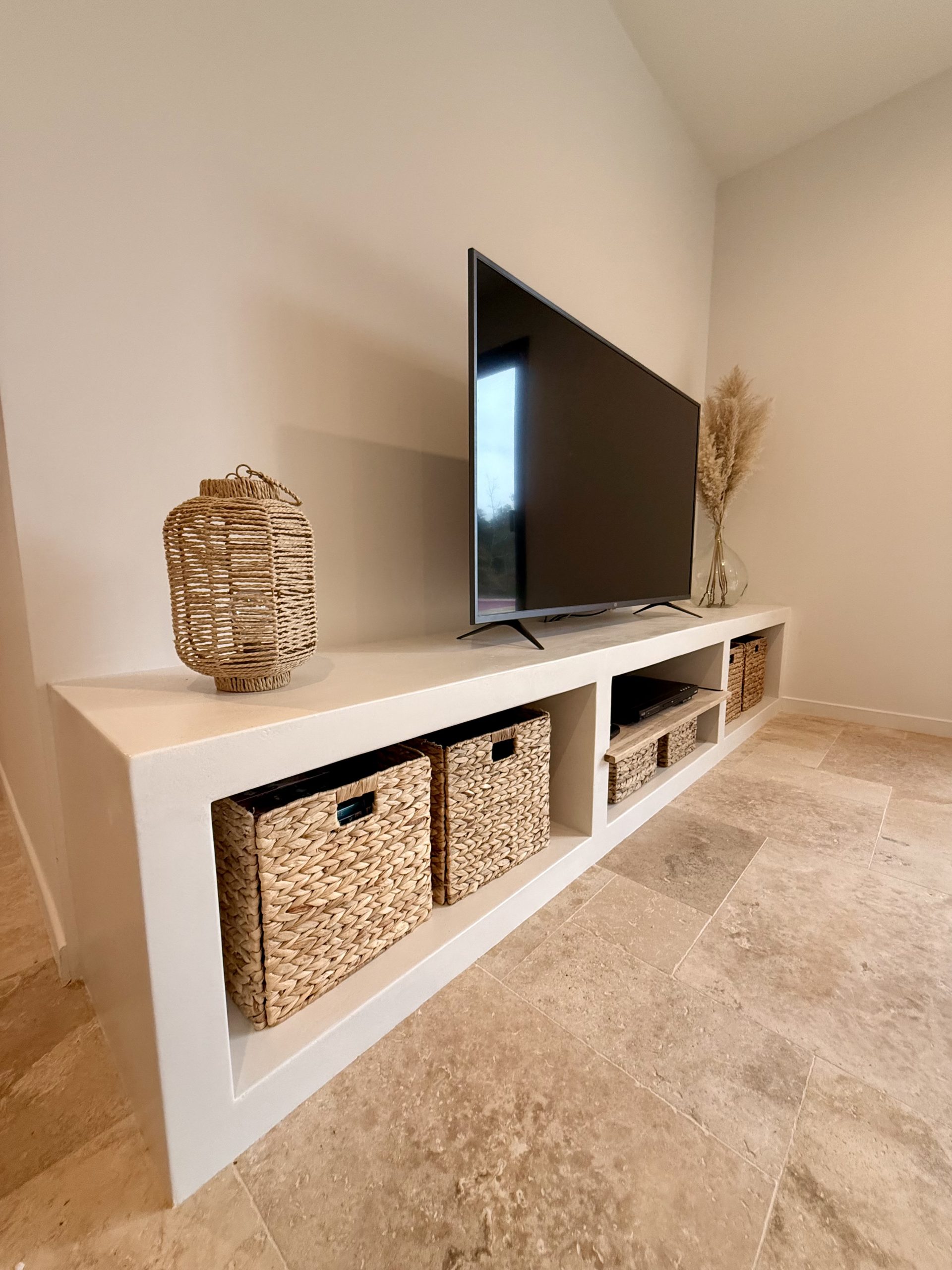 Meuble TV sur mesure en béton ciré avec rangements intégrés, mise en oeuvre à La Garde par Clavel Rénovation.
