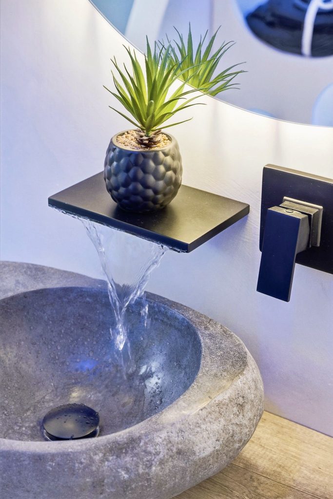 Vasque en pierre avec robinet mural et tablette décorative béton ciré salle de bain haut de gamme à Hyères par Clavel Rénovation