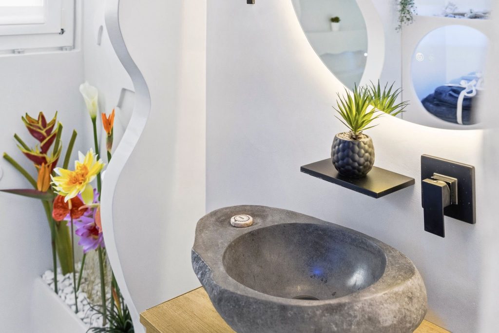 Vasque en pierre naturelle avec robinet noir sur meuble béton ciré salle de bain Hyères par Clavel Rénovation
