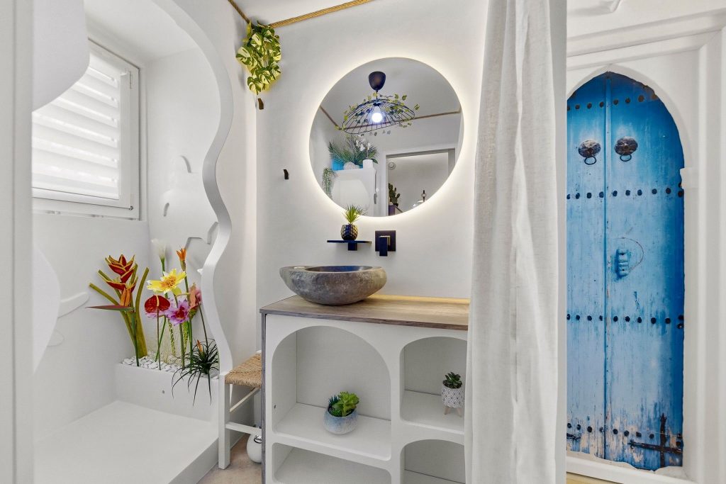 Salle de bain design en béton ciré blanc avec niche murale et porte bleue réalisée à Hyères-les-palmiers, par Clavel Rénovation