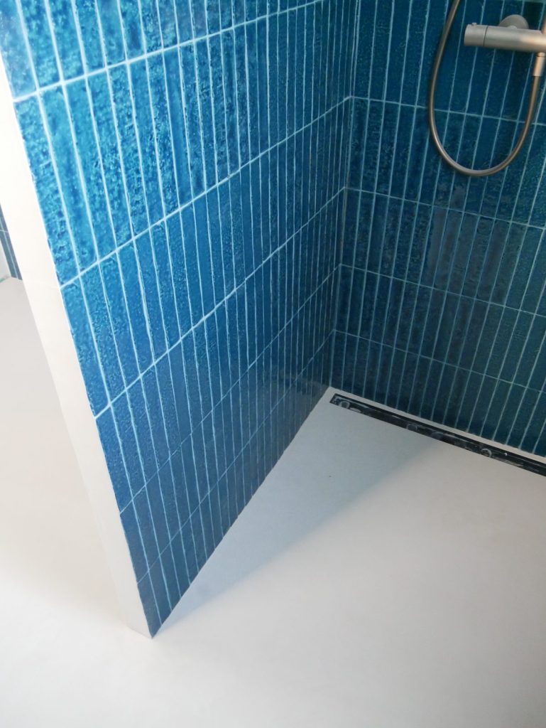 Douche à l'italienne avec sol en béton ciré blanc : avantages du béton ciré en pièce humide