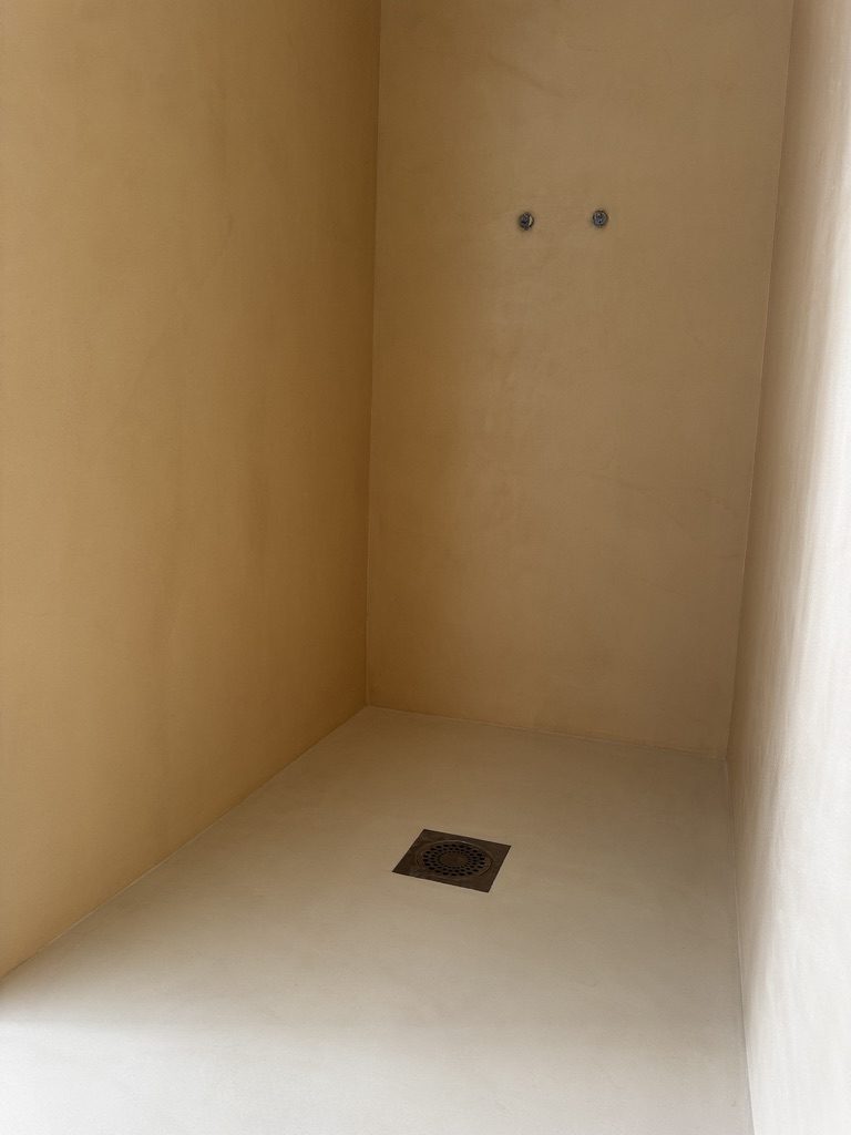 Douche à l'italienne en béton ciré intégral, sol et murs sans joint, dans le Var