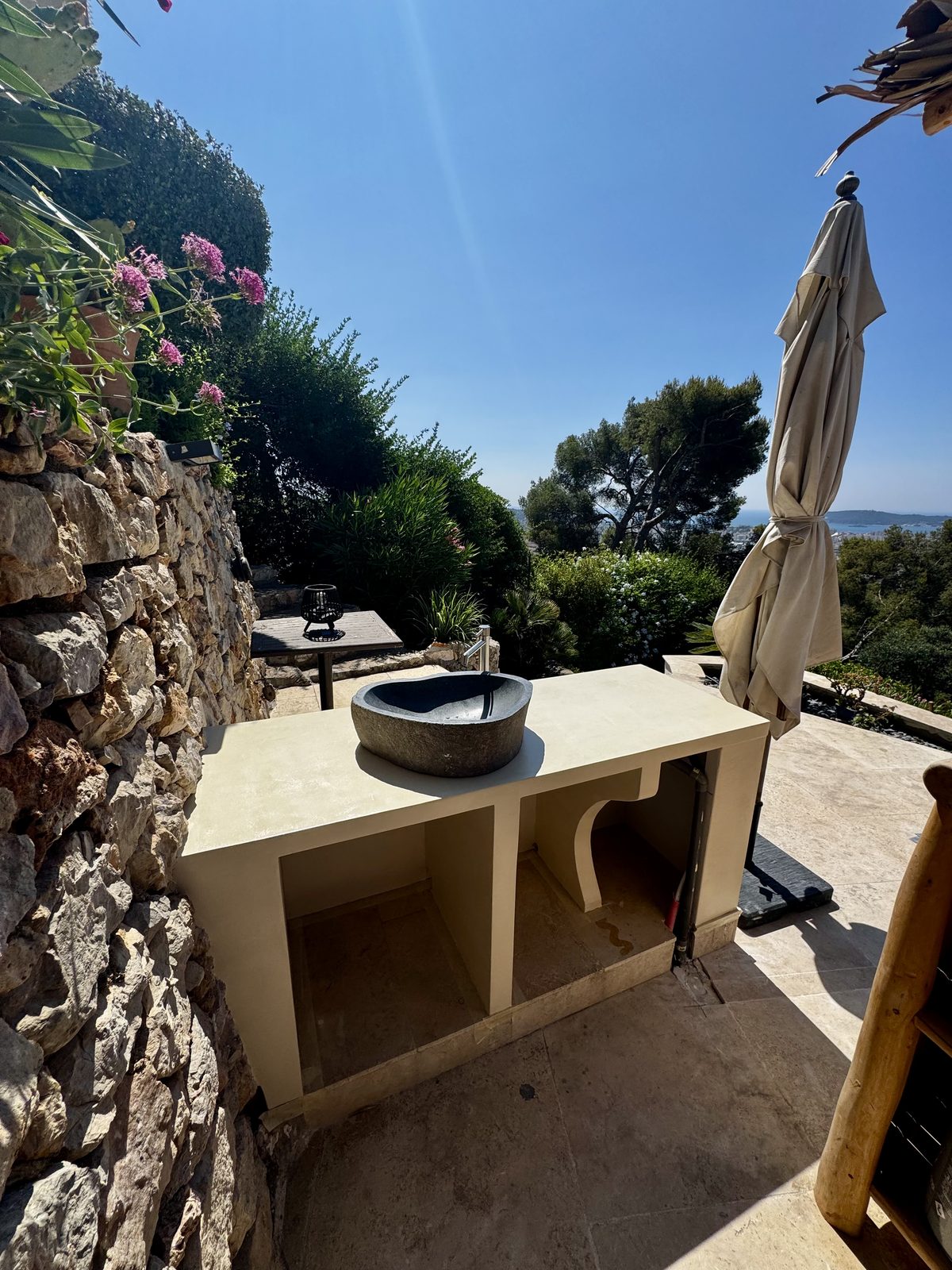 Plan de travail en béton ciré et vasque en pierre d'une cuisine d'été à Toulon